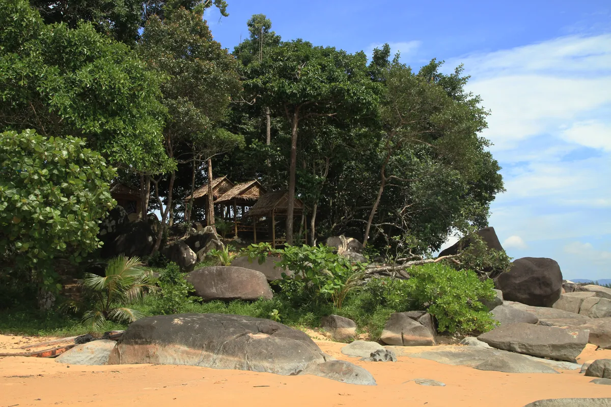 Vegetazione tropicale e massi granitici sulla costa di Bang Niang a Khao Lak, in Thailandia, con sabbia chiara sul mare delle Andamane