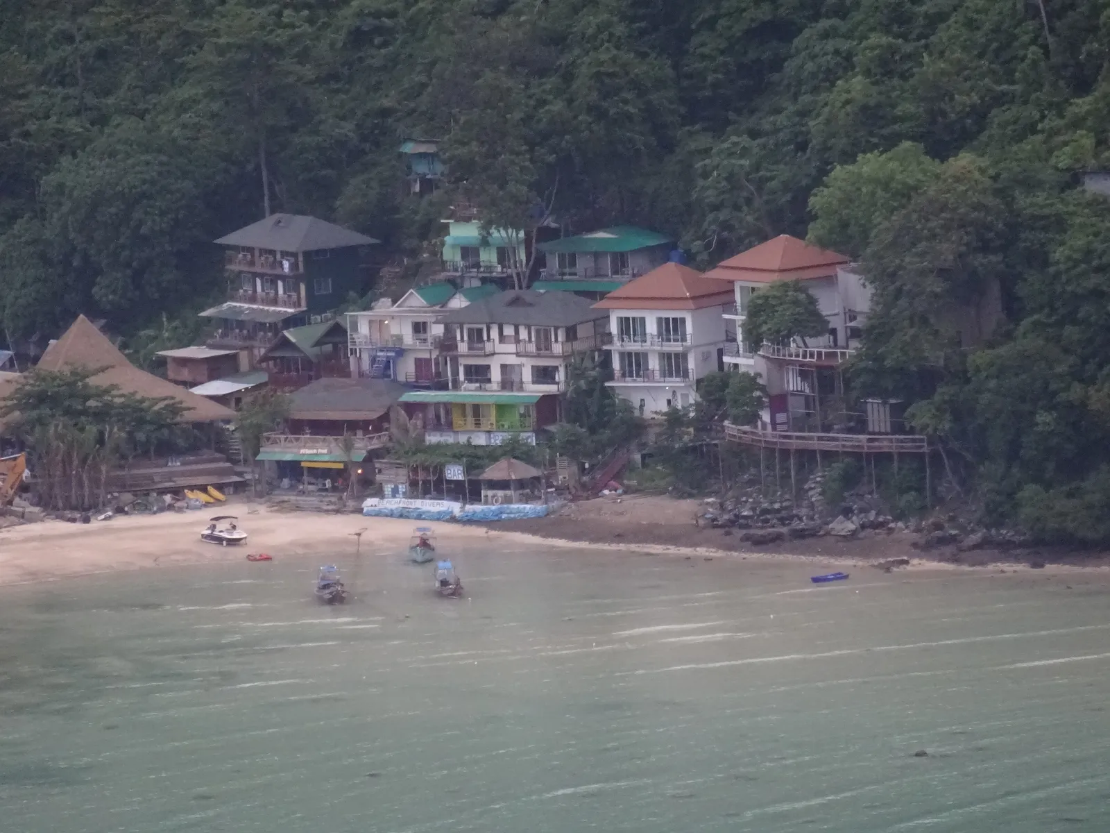 Resort sulla baia di Loh Dalum Resort e case tra la vegetazione sulla baia di Loh Dalum a Koh Phi Phi Don, Thailandia, con il mare e le barche in primo piano
