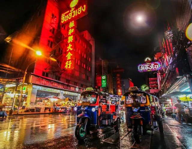 Tuk-tuk di notte a Chinatown, Bangkok Tuk-tuk di notte in Chinatown (Yaowarat) a Bangkok, tra insegne al neon e luci riflesse sull'asfalto bagnato