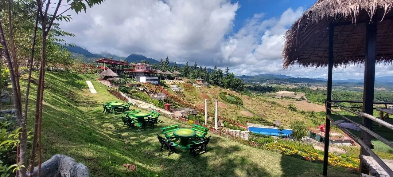 Giardino panoramico con tavolini e vista sulla vallata di Pai e sulle montagne del nord-ovest della Thailandia