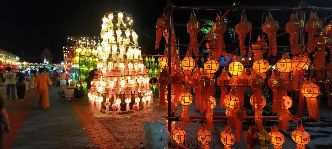 Le installazioni di lanterne del Festival delle 100.000 Lanterne a Lamphun Le installazioni luminose del Festival delle 100.000 Lanterne a Lamphun: una torre di lanterne bianche e file di lanterne arancioni accese di notte