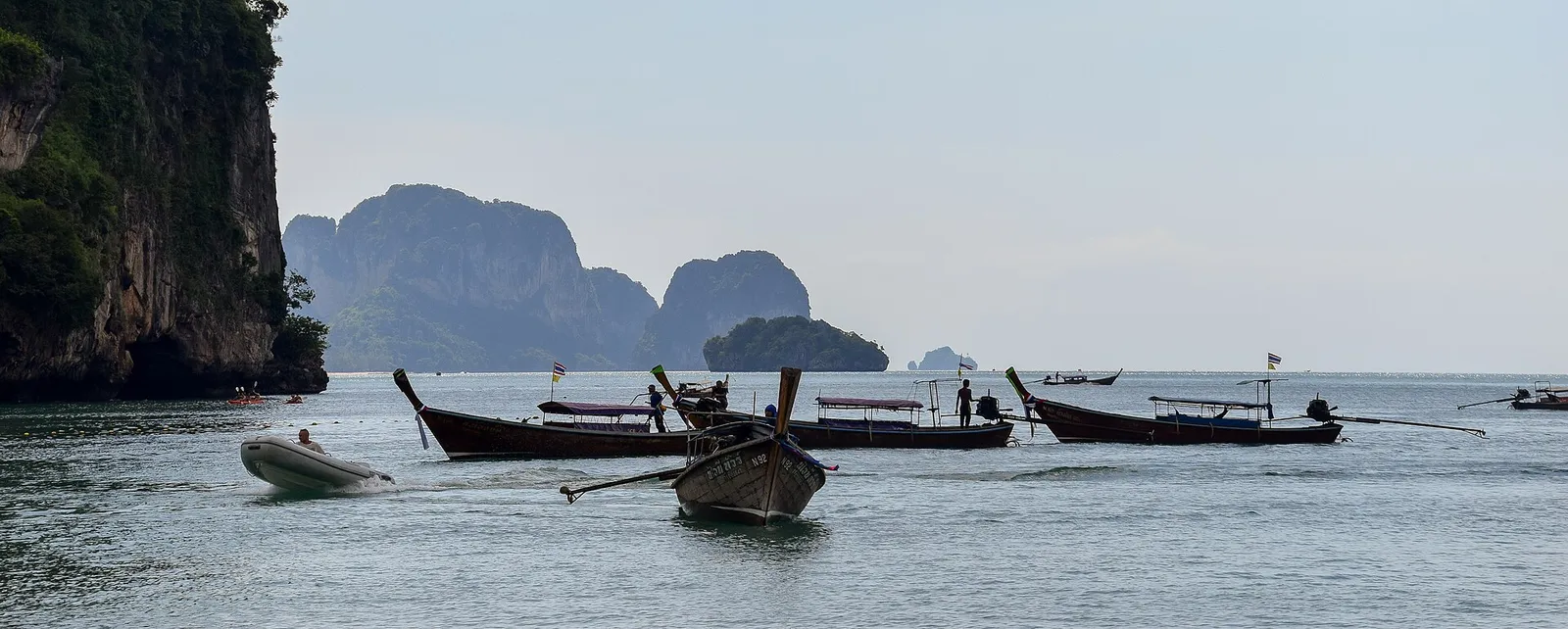 Barche longtail ormeggiate sulla sabbia di Railay Beach a Krabi, in Thailandia, con le falesie sullo sfondo