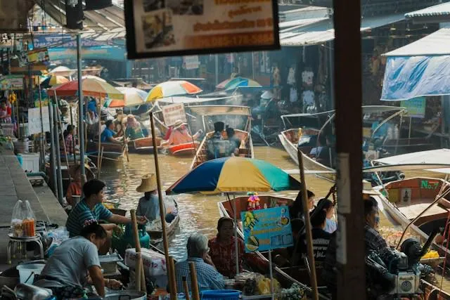 Il mercato galleggiante di Amphawa tra barche e ombrelloni colorati Barche e ombrelloni colorati tra i venditori sul canale del mercato galleggiante di Amphawa