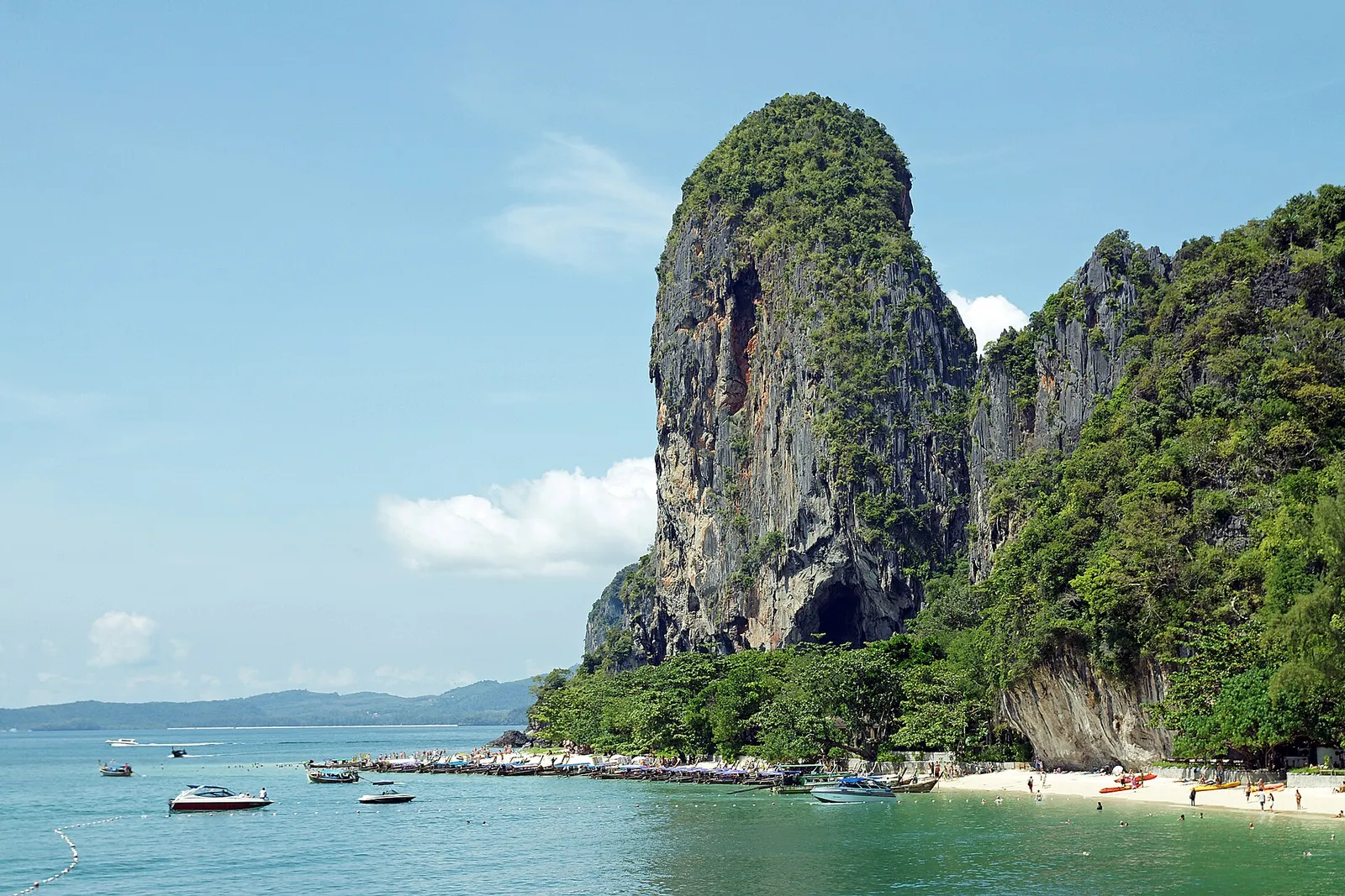 Phra Nang Beach a Railay, in Thailandia, con la grande formazione rocciosa a picco sul mare, le barche e la grotta della principessa
