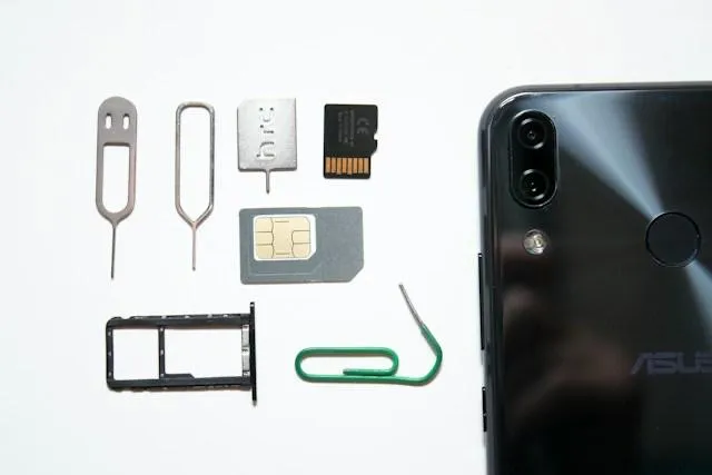 SIM card, strumenti per estrarla e smartphone su sfondo bianco, pronti per attivare la connessione internet in viaggio in Thailandia