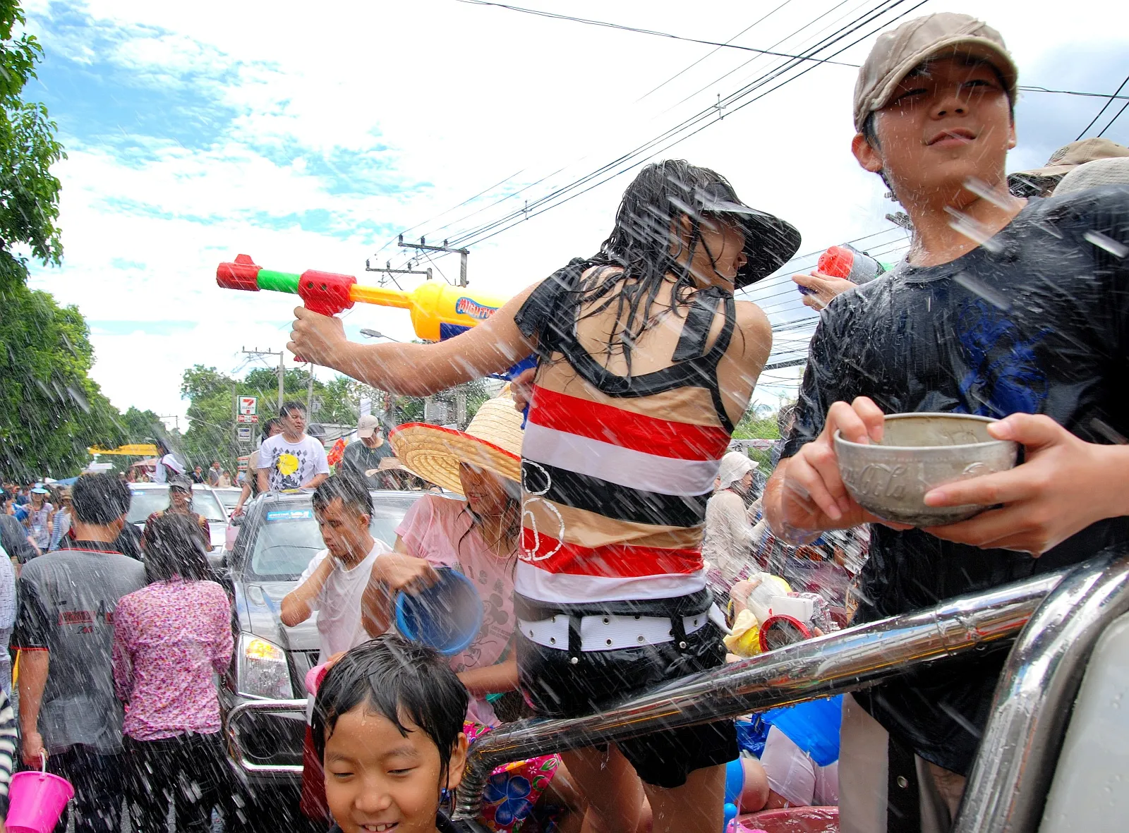 La battaglia d'acqua di Songkran nelle strade thailandesi Ragazzi e bambini thailandesi si spruzzano acqua in strada durante il festival Songkran, il capodanno thai
