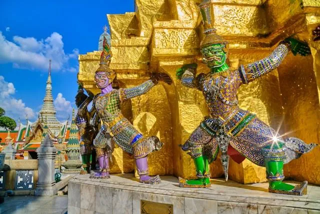 Le statue guardiane del Wat Phra Kaew, Bangkok Le statue guardiane yaksha del Wat Phra Kaew a Bangkok in Thailandia, figure colorate che sorreggono il muro dorato del tempio