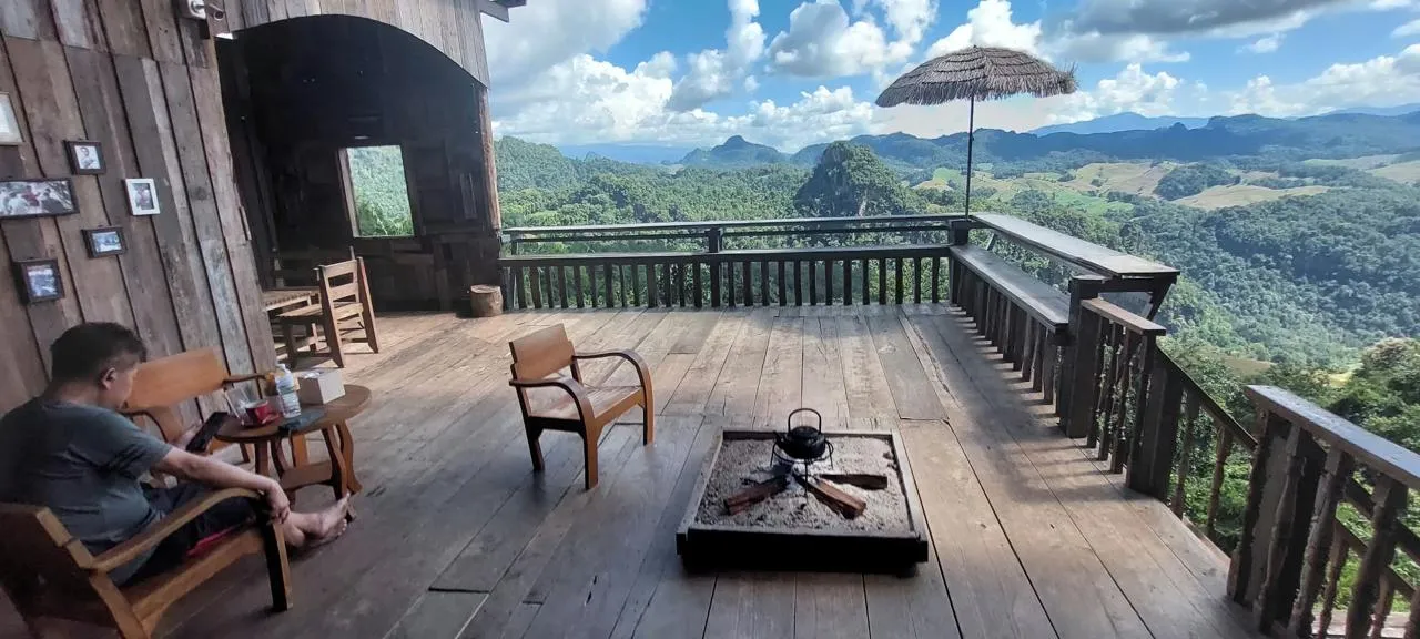 Terrazza panoramica in legno con vista sulla vallata verde delle montagne intorno a Pai, nel nord-ovest della Thailandia