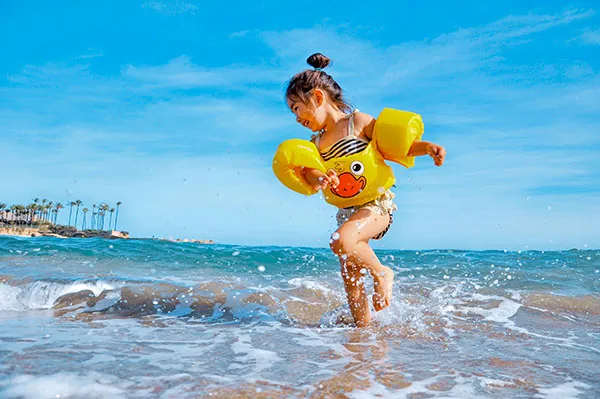 bambina gioca tra le onde di Koh Samui