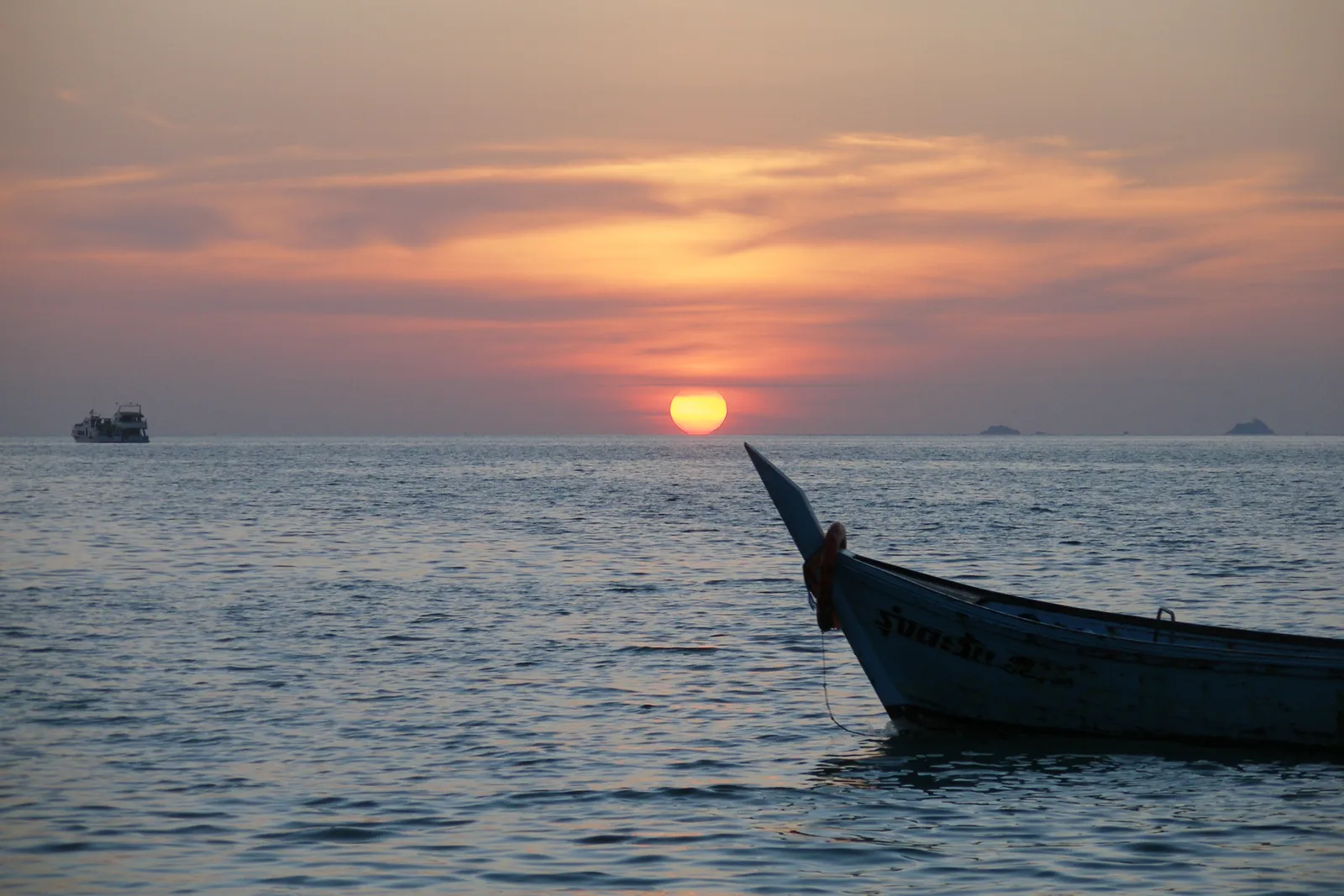 Tramonto a Koh Lipe Tramonto sul mare con barca longtail davanti alla costa di Koh Lipe nello stretto di Malacca