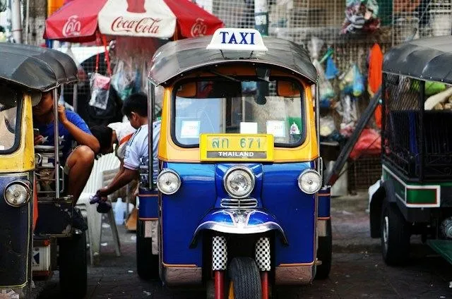 Tuk tuk colorati in un mercato in Thailandia Tuk tuk colorati in attesa in un mercato di strada in Thailandia, il mezzo iconico da contrattare prima di salire
