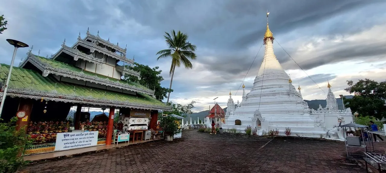 Lo stupa bianco di Wat Phra That Doi Kong Mu e il santuario con il tetto verde intagliato, nel cortile del tempio sopra Mae Hong Son