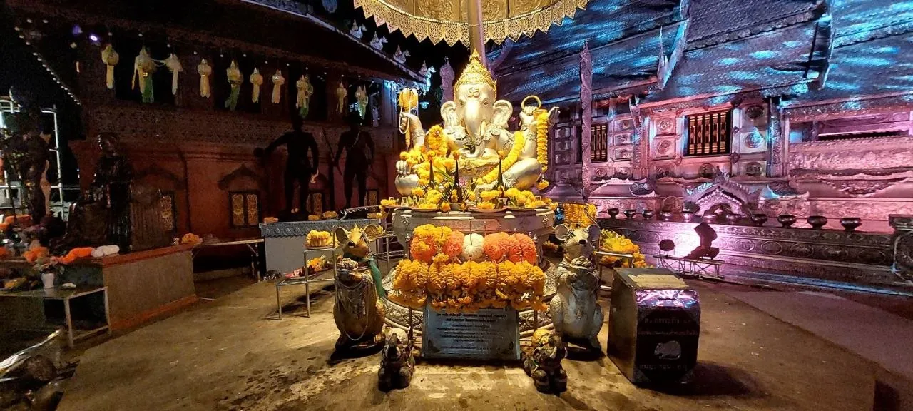 Wat Sri Suphan, la statua di Ganesha nel tempio d'argento di Chiang Mai Statua dorata di Ganesha circondata da offerte di fiori nel tempio d'argento Wat Sri Suphan a Chiang Mai, di notte